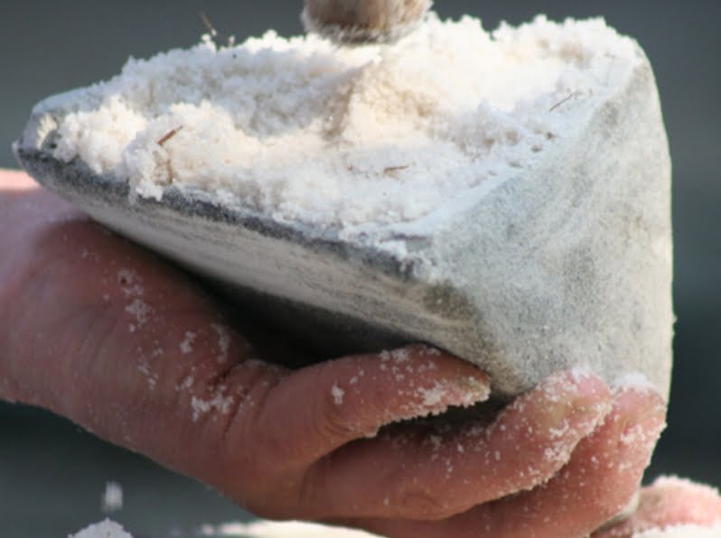塩を土器に詰め込む作業